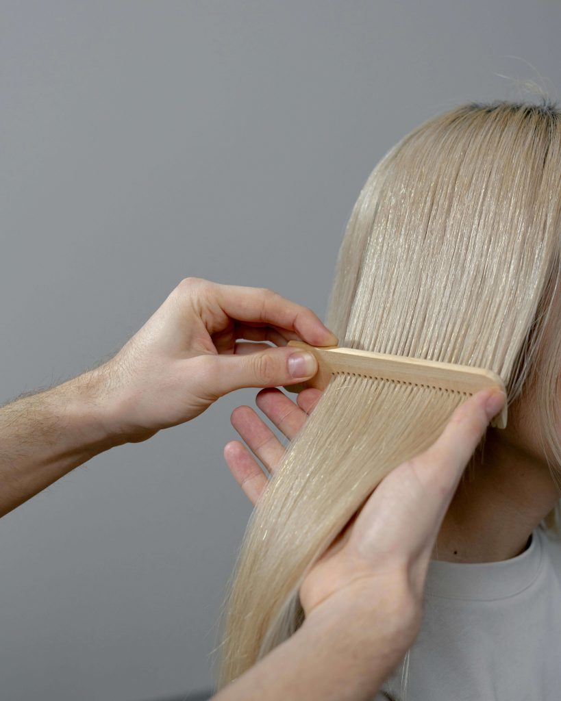 close up of smooth, shiny blonde strands showing healthy hair after bleaching