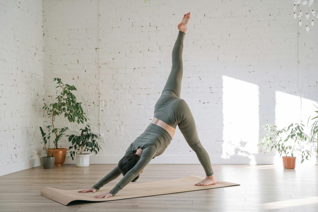 Yoga practitioner stretching and balancing indoors, showcasing exercises for a healthy and strong body